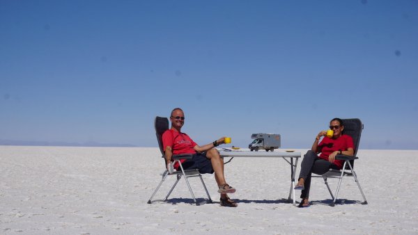 Christin Behle und Thomas Hentzschel 2017 in der Salar de Uyuni in den Anden Boliviens. Die Salar gilt als "größte Salzpfanne der Erde". Wie eine Fata Morgana scheint ihr Reisemobil auf dem Tisch zu stehen. - © Hentzschel