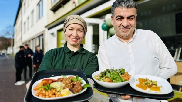 Stephanie und Mehmet Dikilitas präsentieren vor ihrem "Café Sesam" in der Kreuzstraße frisch zubereitete Speisen. - © Stefan Becker