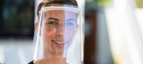 Schüler Bastian Steinlein trägt ein von ihm mittels 3D-Drucker angefertigtes Faceshield. - © picture alliance