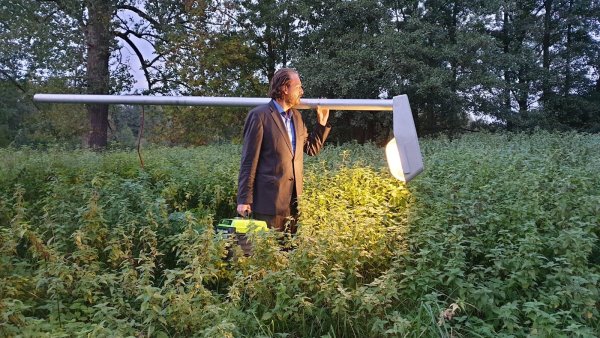 Künstler Jan Philip Scheibe stapft mit seiner Laterne durch ein Brennnessel-Feld. - © Nadine Uphoff