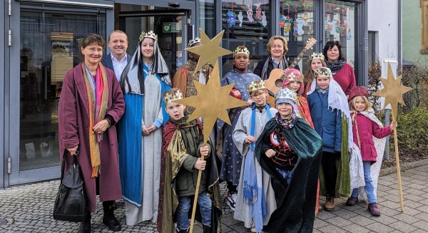 Die Initiatoren Ursula Kuhfuß (links) und Pastor Thorsten Rosenau (hintere Reihe, Zweiter von rechts) mit Bürgermeister Mario Hecker (Zweiter von links), Fachbereichsleiterin Andrea Batzer (hintere Reihe, rechts) und den Sternsingern vor dem Rathaus der Gemeinde Kalletal. - © Fotorechte: Gemeinde Kalletal