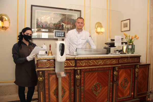 Gästeempfang im Detmolder Hof: Geschäftsführer Jan Diekjobst steht hinter einer Plexiglasscheibe, die angehende Hotelfachfrau Karine Karapetyan hält Listen bereit, in die sich jeder Gast eintragen muss. Eine Desinfektion der Hände ist auch erwünscht.  - © Cordula Gröne