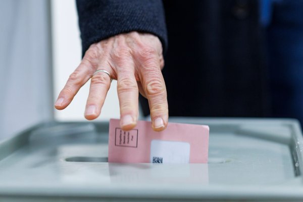 Ein Mann wirft seine Wahlunterlagen in eine Wahlurne. - © Christoph Reichwein/dpa