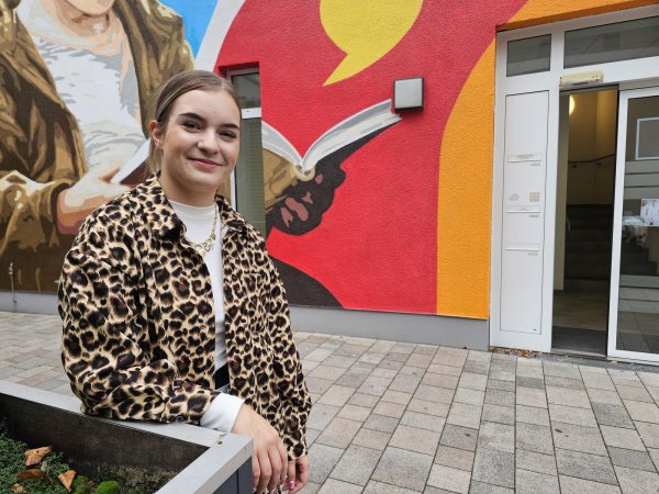 Lea Pommerenk liebt die Kunst und findet die Fassadenkunst an der Stadtbücherei klasse. Die 23-Jährige plant im Stadtmarketing für Lage einige neue Projekte. - © Astrid Sewing