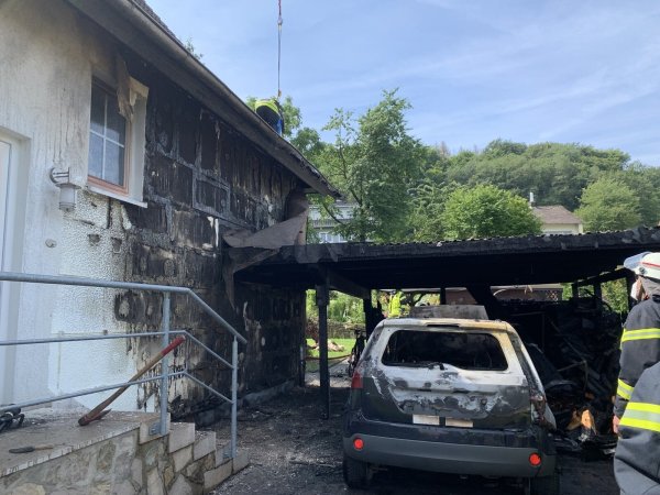 Der Ford Fiesta sowie das Carport sind durch das Feuer vollständig zerstört worden. Auch die Hauswand hat großen Schaden genommen. - © Daniel Hobein / Feuerwehr Bad Salzuflen