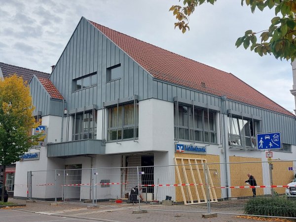 Die Volksbank-Filiale ist mit einem Zaun abgesperrt. Die kaputten Fenster und Türen werden provisorisch durch Holzplatten gesichert. - © Michaela Weiße