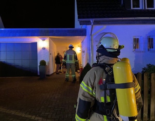 Vor dem Einfamilienhaus in der Straße "Am Steinbrink" stehen Feuerwehrleute. - © Daniel Hobein / Feuerwehr Bad Salzuflen