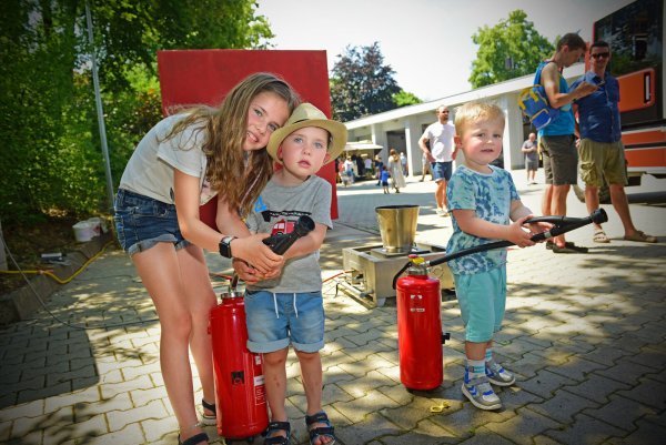 Lotta, Pepe und Bjakri (von links) testen die mit Wasser befüllten Feuerlöscher. - © Nicole Ellerbrake