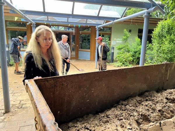 Melanie Sudmann (stellvertretende Kitaleiterin) schaut sich die volle Mulde an. Das Gärtnerteam der AWO hat am Mittwoch die meisten Wege rund um das Gebäude wieder einigermaßen freigeräumt. - © Seda Hagemann