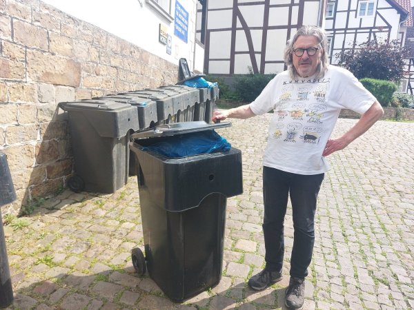 Andreas Wellmann aus Schwalenberg ist verärgert, dass seine Mülltonne nicht geleert wurde. Auch am Hotel-Restaurant "Malkasten" stehen die noch vollen Tonnen an der Hauswand. - © Michaela Weiße