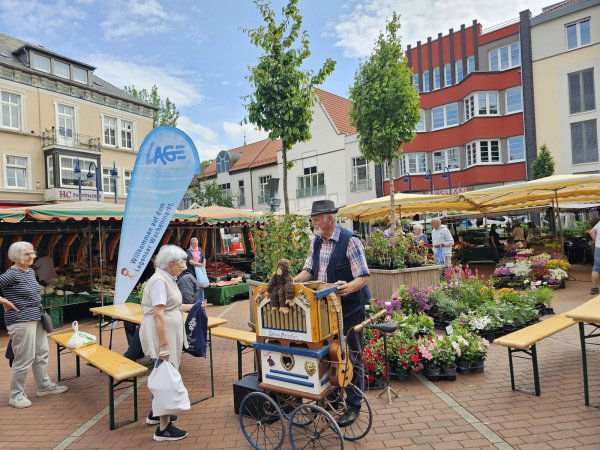 Sieglinde Ullmann besucht gerne den Wochenmarkt in Lage. Als Hans-Dieter Stieber mit seinem Leierkasten vorbeikommt, kommt sie mit ihm ins Gespräch. - © Astrid Sewing