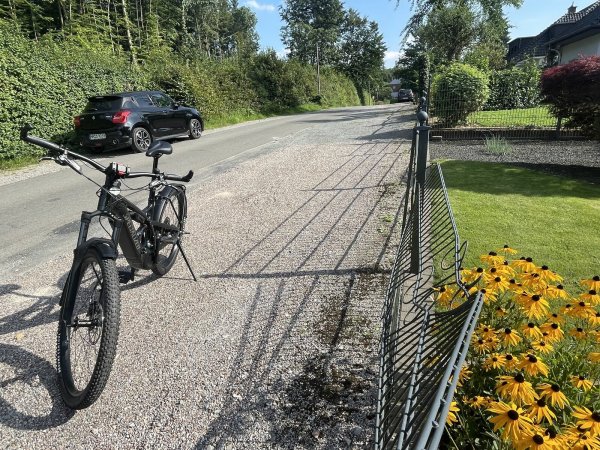 Wo die Roteiche von dem bewaldeten Grundstück (links) auf den Zaun gefallen ist, hat sie Spuren hinterlassen. Der Zaun ist noch nicht repariert. Auf der Kiesfläche stand der BMW, der bei dem Ereignis total demoliert wurde. - © Silke Buhrmester