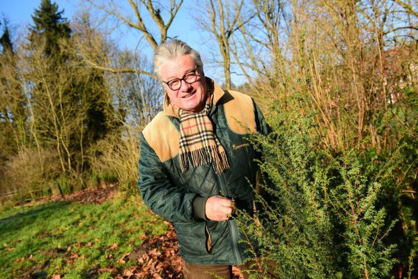 Friedhelm Begemann mit einem Wacholder. Die Pflanzen sind vielfältig nutzbar. Sie bieten Tieren Schutz, sind gut für das Ökosystem und ihre Beeren sind nicht nur Grundlage für Schnaps, sondern auch als Gewürz einsetzbar.  - © Nadine Uphoff