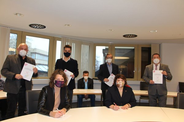 Die Grünen links, die Sozialdemokraten rechts: Fraktionsvorsitzender Werner Loke und Kreis-Parteisprecher Robin Wagener stehen hinter Kreissprecherin Dr. Inga Kretzschmar (vorne links), für die SPD unterschreibt die Kreisvorsitzende Ellen Stock. Hinter ihr stehen Fraktionsvorsitzender Henning Welslau und Landrat Dr. Axel Lehmann. Andreas Kuhlmann (SPD) unterzeichnet den Koalitionsvertrag als Mitglied der Landesverbandsversammlung. - © Astrid Sewing