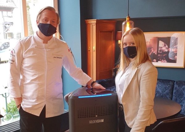 Jan Diekjobst und eine Mitarbeiterin stellen die Luftreiniger im Restaurant des Detmolder Hofes auf. - © Henrik Wand/Visiontwo GmbH