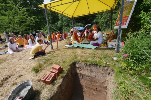 Hindu-Priester Siva Sri Arumugam Paskarakurukkal legt auf dem Yoga-Vidya-Gelände weiht bei einem religösen Ritual den Baugrund für den Hindu-Schrein „Sri Ganapati Vidya Mandapa“. Links von ihm nimmt Yoga-Vidya-Gründer und -Leiter Sukadev Volker Bretz an der Zeremonie teil. Vorne ist die Baugrube mit den Grundsteinen zu sehen. - © Jost Wolf
