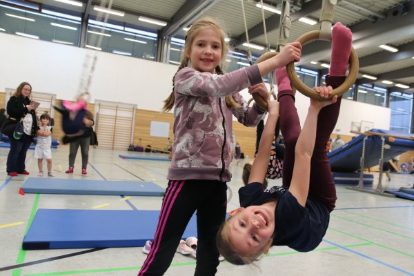 Beim Spielfest kann man auch neue Sportgeräte kennenlernen. Lenja (rechts) hat mit Unterstützung ihrer Cousine Nele (links) keine Hemmungen an den Ringen. Foto: Knut Dinter - © Knut Dinter