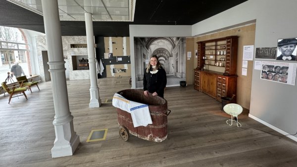 Sonja Beinlich an der Moorbadewanne in der Ausstellung. Rechts in der Ecke steht der historische Schrank der Brandes'schen Apotheke. - © Sven Kienscherf