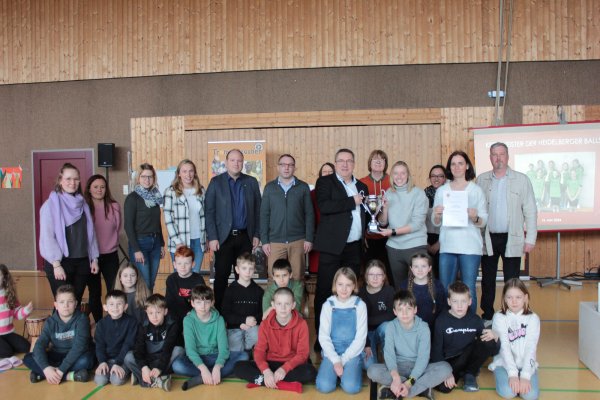Landrat Dr. Axel Lehmann überreicht Sportlehrerin Mareile Niederkrüger von der Grundschule Großenmarpe
den Pokal des Landrats. Mit ihr freuen sich die Sportlehrerinnen der Schule sowie Bürgermeister Christoph Dolle (5. von links) und Schulleiter Carsten Baumfelder (rechts). - © Kreis Lippe
