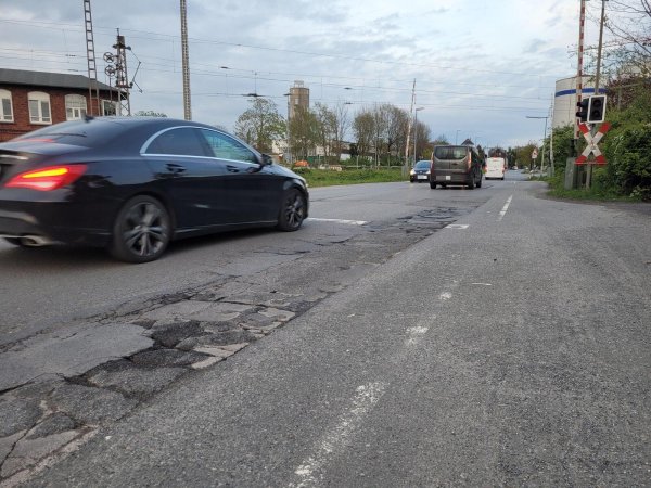 Die Straße am Bahnübergang hinter dem Marktkauf ist eigentlich nur noch eine Aneinanderreihung von Schlaglöchern und Flickwerk. Das soll sich ändern, und nicht nur am Bahnübergang an der Heidenschen Straße stehen Arbeiten an. - © Astrid Sewing