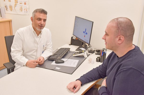 Während der Nachsorge untersucht der Paderborner Neurochirurg Abdulhannan Alaboud die künstliche Schädeldecke seines Patienten Pavlo L., der bald wieder arbeiten will. - © Brüderkrankenhaus St. Josef