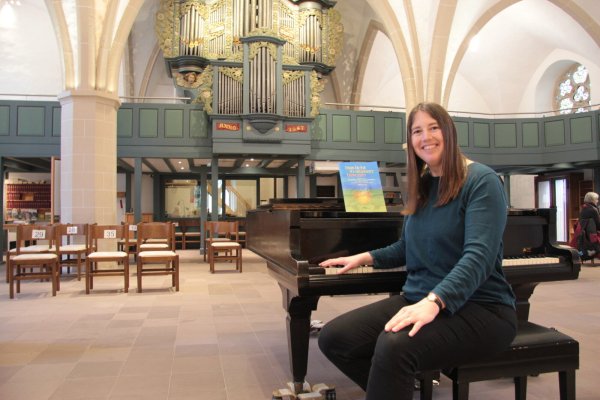 Lea Marie Lenart ist die neue Kantorin der Lagenser Marktkirche. Die Noten auf dem Flügel sind die Grundlage für ein anstehendes Chorkonzert. Für das Gemeindehaus sucht die Gemeinde noch einen Flügel. - © Karolina Schmidt