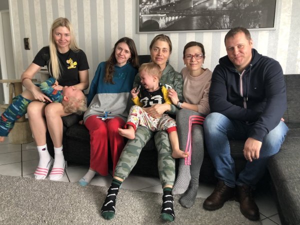 Natalia (von links) mit Sohn Mathew und Tochter Milena, Helena mit Sohn Timur sowie Ina und Dennis Zinn sitzen im Wohnzimmer der Bad Salzufler. - © Sven Kienscherf