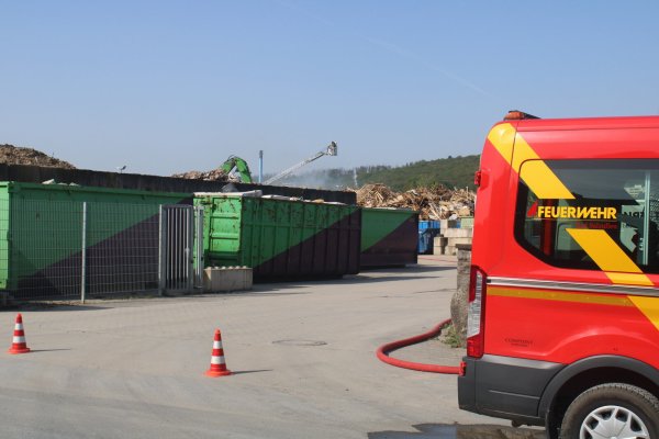 Rund 50 Einsatzkräfte sind auf Gelände eines Entsorgungsbetriebes in der Bad Salzufler Siemensstraße vor Ort. Dort brannte zunächst ein Stapel mit Papier, dann griff das Feuer auf einen Holzstapel über. Mittels der Drehleiter wurde die angrenzende Lagerhalle vor dem Brand geschützt. - © Feuerwehr Bad Salzuflen