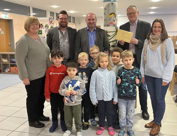 Kita-Leiterin Ute Bertling, 1. Adjutant Björn Cruel, Schatzmeister Marcus Pemeyer, Oberst Michael Krügermeyer-Kalthoff, Kita-Leitein Kristina Schiller (von links) und einige Kita-Kinder während der Spendenübergabe. - © Schützengilde Lage