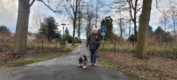 Seniorenbeauftragter Werner Wahlers mit Juno vor dem Radweg, der über den Friedhof Rintelner Straße führt. Diese direkte Querung hinüber zur Straße Hinter den Friedhöfen ist erlaubt, nicht aber auf den anderen Wegen. - © Katrin Kantelberg