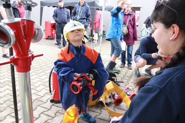Zur Ausrüstung eines richtigen Feuerwehrmannes gehören Helm und Strahlrohr. Am Stand der Jugendfeuerwehr wurde Johannes von Lia Seifert (rechts) zur Probe eine echte Dienstkleidung angelegt – freilich noch ein paar Nummern zu groß. Fotos: Knut Dinter - © Knut Dinter