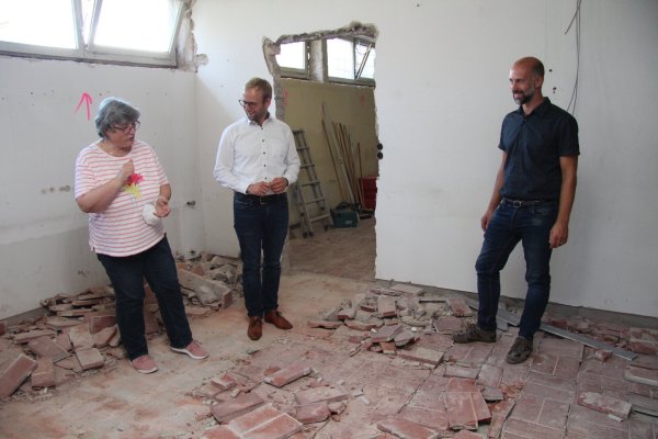 Schulleiterin Gabriele Schmuck (von links), Bürgermeister Borris Ortmeier und Fachbereichsleiter Chris Hütte-Getboga schauen sich die Abbrucharbeiten am Gymnasium an. - © Nadine Uphoff