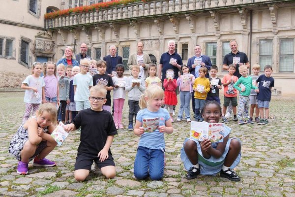 Freuen sich zusammen mit der 1a der Grundschule am Schloss: Jörg Franks, Schulleiter der Grundschule am Schloss, Landrat Dr. Axel Lehmann, Manfred Hütte, Verlagsleiter vom Kurier Verlag, Hermännchen-Zeichner Mark Schäferjohann, Dr. Albert Hüser, Vorsitzender vom Lippischen Heimatbund, Jörg Düning-Gast, Verbandsvorsitzender vom Landesverband Lippe und Klassenlehrerin Alexandra Kehl (von rechts). - © Kreis Lippe