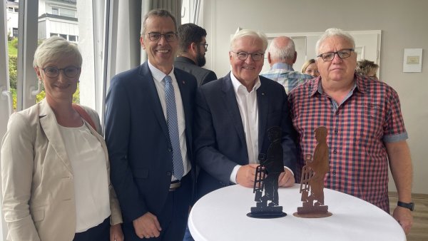 Jürgen Koch (rechts) überreicht Bundespräsident Frank-Walter Steinmeier (Zweiter von rechts) beim Imbiss in der Alten Schule in Brakelsiek den ersten Ziegler im Miniformat. Bürgermeister Jörg Bierwirth und Gattin Astrid gefällt der Prototyp auch gut. - © Silke Buhrmester