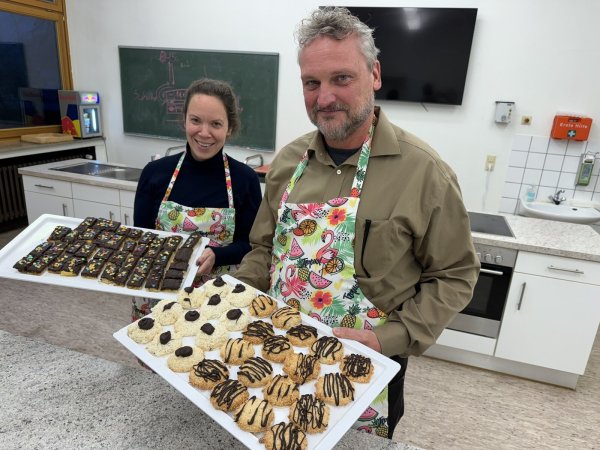 Kai Dommermuth leitet die Schülerinnen und Schüler aktuell beim Backen von Keksen an und freut sich mit Schulleiterin Dorothee Kriener über die Ergebnisse. - © Sandra Castrup