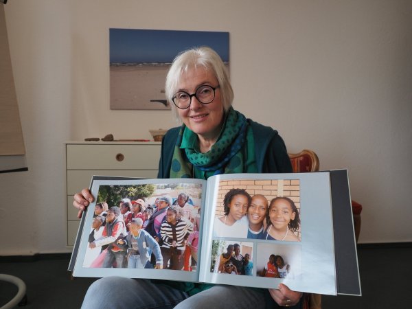 Bunte Erinnerungen: Pastorin Kornelia Schauf hat zum Abschied von ihren südafrikanischen Gemeindemitgliedern einen Bildband mit Impressionen aus ihrer Zeit in Südafrika bekommen. - © Andreas Barnekow