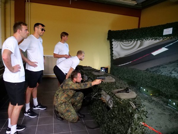 Oberstabsgefreiter Woldemar Sarkisjan zeigt (von links) Bobby Schagen, Isaias Guardiola, Jonathan Carlsbogard und Alexander Reimann im Gefechtssimulator den richtigen Umgang mit der P8-Pistole. - © Jörg Hagemann