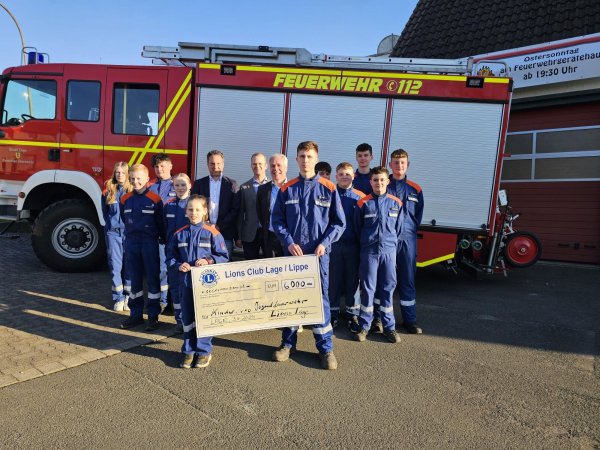 Die Lions Dirk Steinhage (von links), Lars Ruwisch und Präsident Thomas Schäfer (von links) überreichten in Hörste einen dicken Scheck an die Jugendfeuerwehr Lage. - © Astrid Sewing