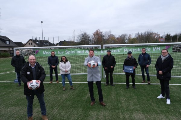 Jugendobmann Arnd Bracht (links) und Bürgermeister Frank Hilker (Mitte) halten schon mal die Fußbälle bereit für die ersten Kicks auf dem neuen Kunstrasenplatz. Ortsbürgermeister Christian Fritzemeier (rechts) freut sich mit den weiteren Beteiligten vom Verein, der Stadt, der Schule, der ausführenden Firma und des Stadtsportverbandes.  - © Sven Koch