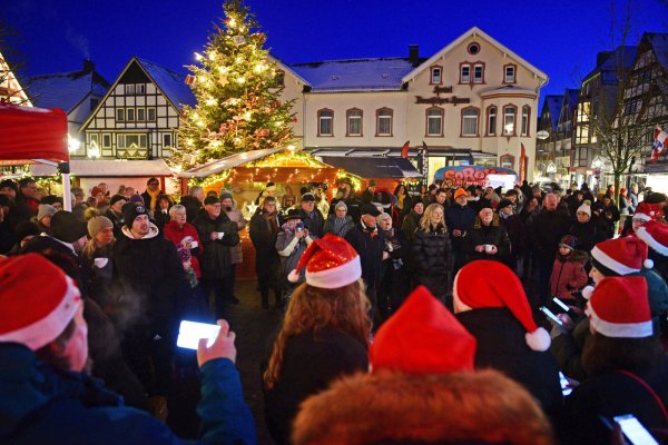 Chor und Besucher singen gemeinsam auf dem weihnachtlich geschmückten Marktplatz. - © Nicole Ellerbrake