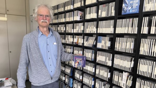 Werner Dabringhaus steht vor dem Regal, das je ein Exemplar sämtlicher CD-Einspielungen enthält, die sein Unternehmen bisher herausgebracht hat. - © Dieter Asbrock