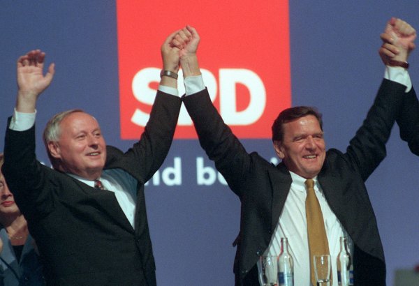 Der damalige SPD-Kanzlerkandidat Gerhard Schröder (r.) und der damalige Parteivorsitzende der Sozialdemokraten, Oskar Lafontaine, halten sich am Abend bei der Wahlkampfabschlussveranstaltung ihrer Partei in Berlin an den Händen. - © Peer Grimm