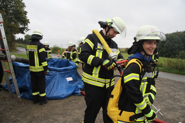 Sören Hollensteiner füllt bei Darius Büker (rechts) einen Löschrucksack. - © Daniel Hobein/Feuerwehr Bad Salzuflen