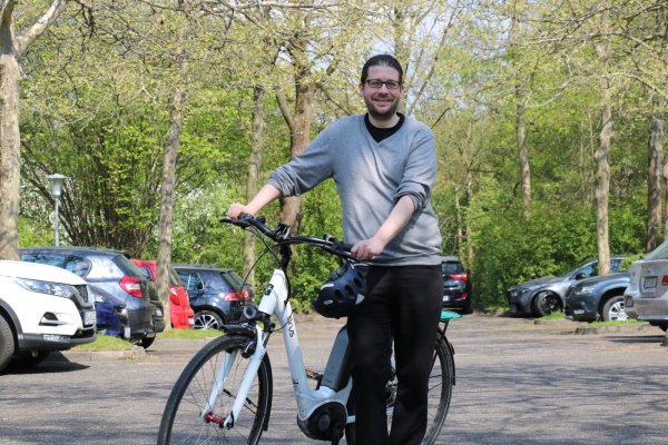 Klimaschutzmanager Lukas Menne steht mit seinem Dienstfahrrad auf dem Parkplatz vor dem Rathaus. Dass Parkflächen zugunsten des Radverkehrs weichen müssen, ist nur eines seiner Themen. - © Alexandra Schaller