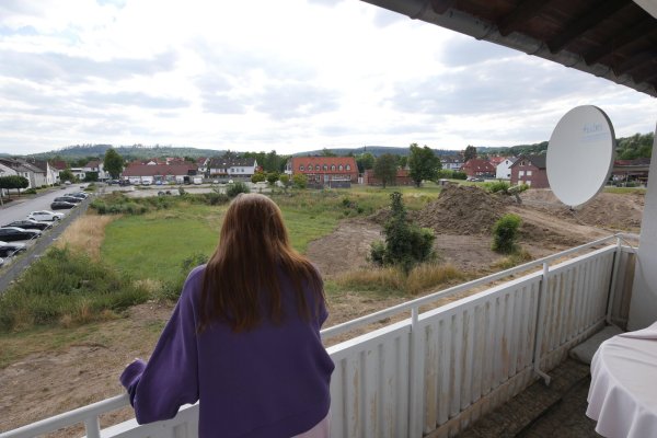 Mieterin Döndü Kuz blickt von ihrem Balkon auf den Bauplatz des Fachmarktzentrums an der Kampstraße. Auch das Mietshaus, in dem sie gemeinsam mit ihren Eltern und einer Nachbarin noch wohnt, soll für das Projekt abgerissen werden. - © Jost Wolf