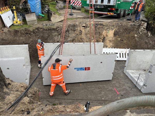 Arbeiter des Fachunternehmens setzen das in vorgefertigten Modulen angelieferte Material für den Gewässerdurchlass zusammen. - © Stadt Lage