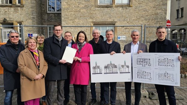 Bürgermeister Matthias Kalkreuter freut sich über den Förderbescheid, den Regierungspräsidentin Anna Katharina Bölling überreicht. Für die politischen Fraktionen sind (von links) Rudi Stölting (CDU), Martina Hannen (FDP), Monika Kuhlmann (Büdnis 90/Die Grünen), Frederik Topp (CDU) und Hans Hofste (SPD) dabei. Die Zeichnungen für den Umbau zeigen Architekt Andreas Rimkeit (Dritter von rechts), der Beigeordnete der Stadt Lage Thorsten Paulussen und Lulzim Malqi (rechts, Rimkeit und Wendler). - © Astrid Sewing