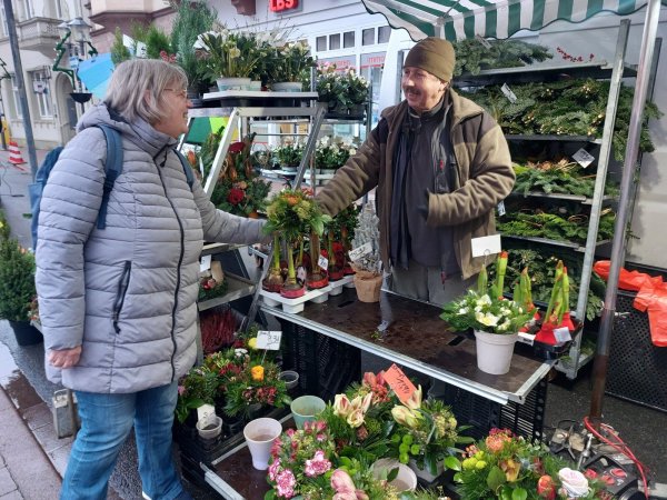 Ingrid Tappe kauft bei Blumenhändler Volker Gebert einen Blumenstrauß. Der Emmerthaler ist seit Mitte September mit seinem Stand auf dem Blomberger Wochenmarkt vertreten. - © Michaela Weiße
