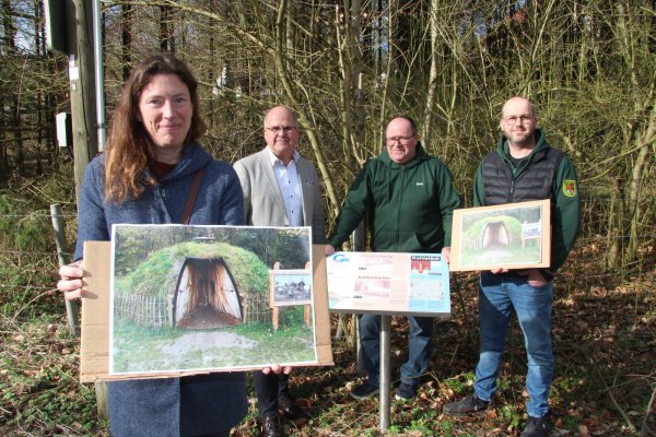 Kathrin Hunstig-Bockholt von der Lokalen Aktionsgruppe Senne³ e.V. zeigt auf dem Foto, wie der Schau-Kohlenmeiler aussehen soll. Im Hintergrund Bürgermeister Marcus Püster, Jens Geise, Vorsitzender der Kohlstädter Schützen, und sein Stellvertreter Nico Hanselle. - © Dieter Asbrock