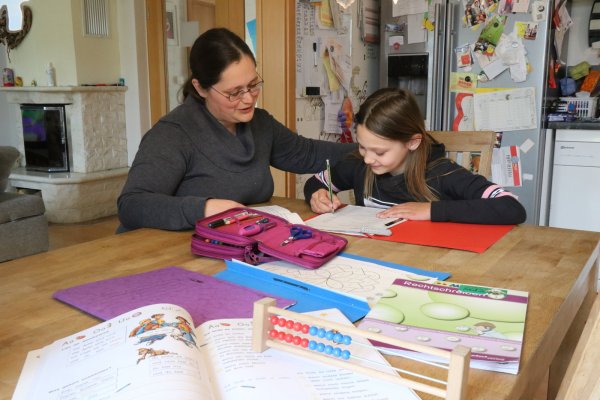 Jessica Erfmann sitzt mit ihrer Tochter Sulaya Angelina (9) am Esstisch und unterstützt sie bei den Hausaufgaben. - © Alexandra Schaller